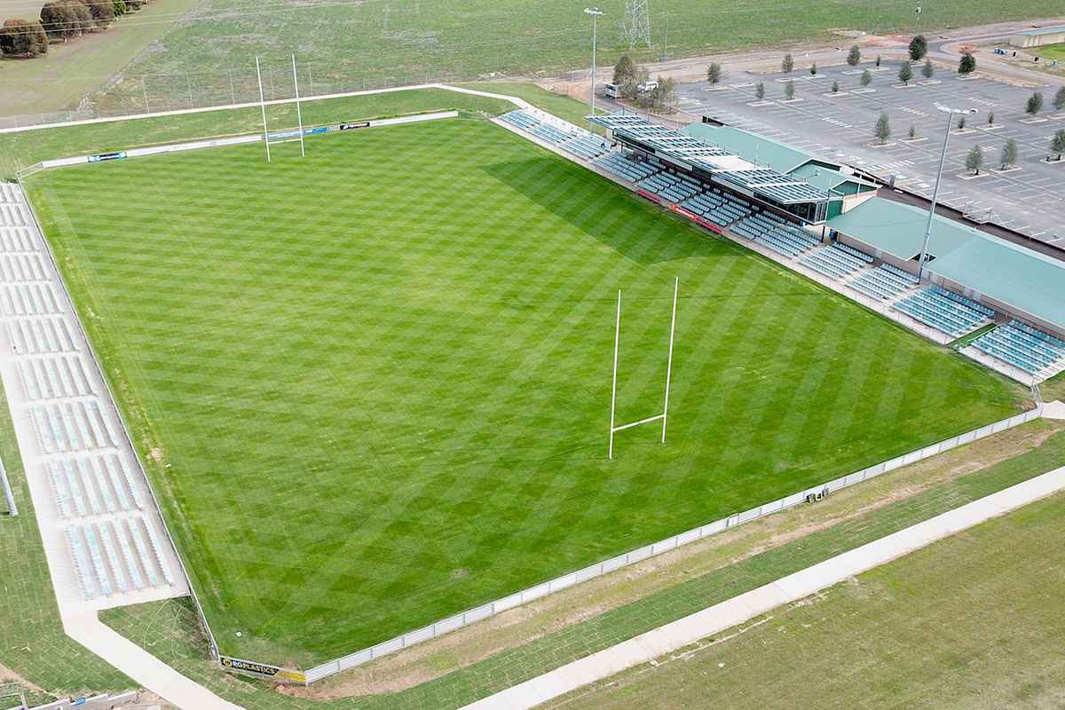 Aerial view of rectangular Rugby League, wiith grandstand and seating on one side.