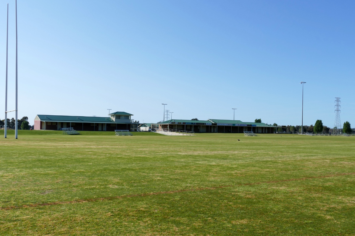 Rugby League football fields and goal posts in the sunshine, with club rooms in the background.