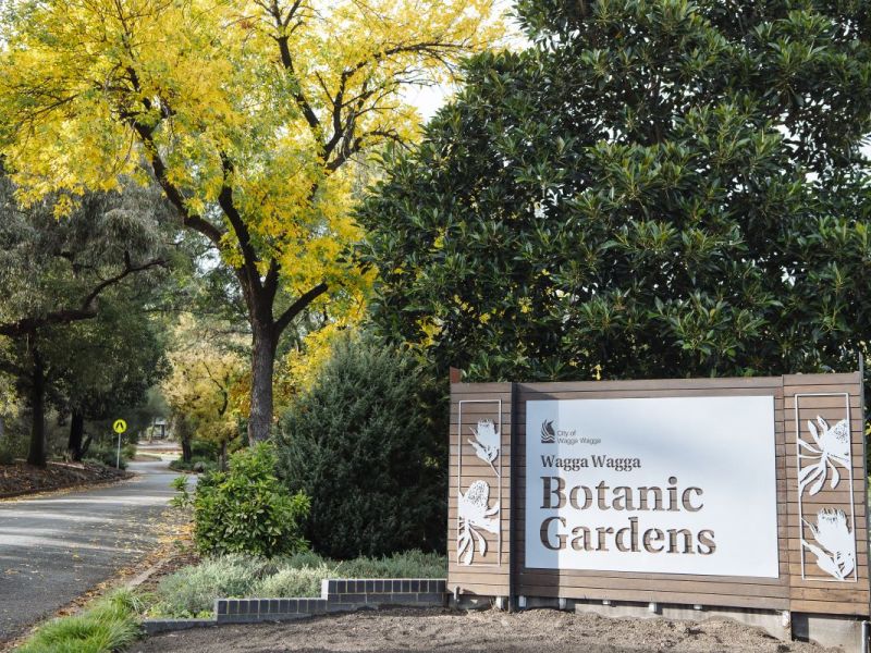 Wagga Wagga Botanic Gardens entrance sign with trees and road in background