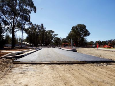 The join between a section of subgrade layer of a road and a layer of fresh asphalt on a road under construction.