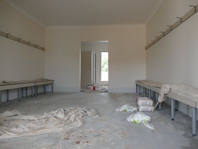 Change room for sporting team, with benches, showers and toilets, and tile walls